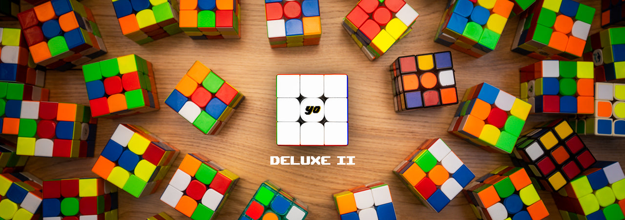 3X3 puzzles all over. Middle 3x3 has a "Yo" logo. Text reads "DELUXE II"